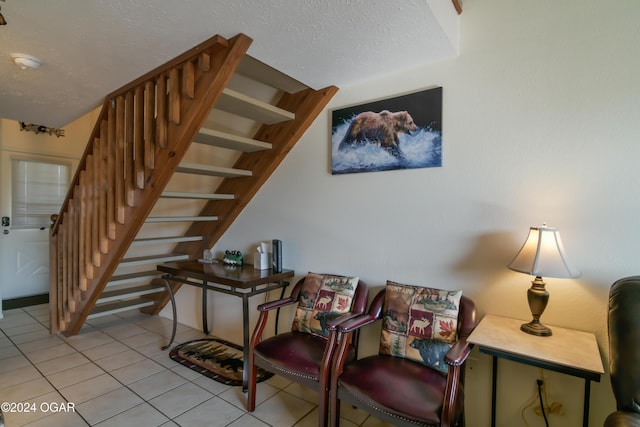 stairs featuring a textured ceiling and tile patterned floors