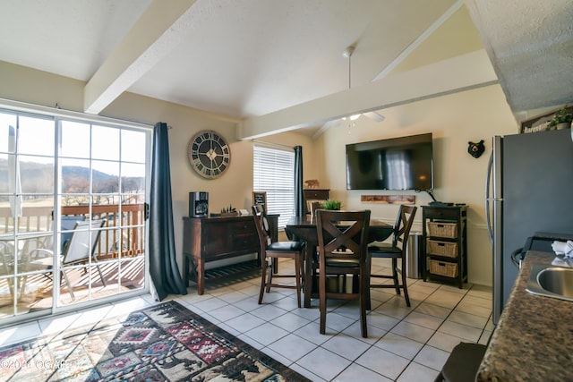 dining area featuring lofted ceiling with beams, plenty of natural light, and light tile patterned flooring