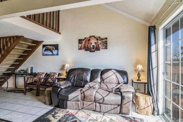 living area featuring lofted ceiling, light tile patterned floors, and stairway