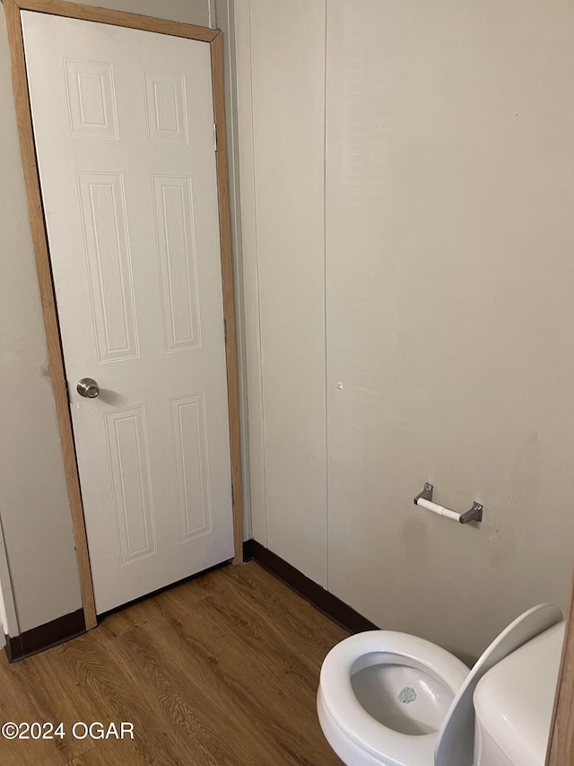 bathroom featuring wood-type flooring and toilet