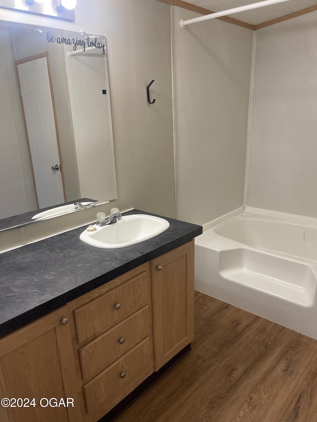 bathroom featuring hardwood / wood-style floors, vanity, and  shower combination