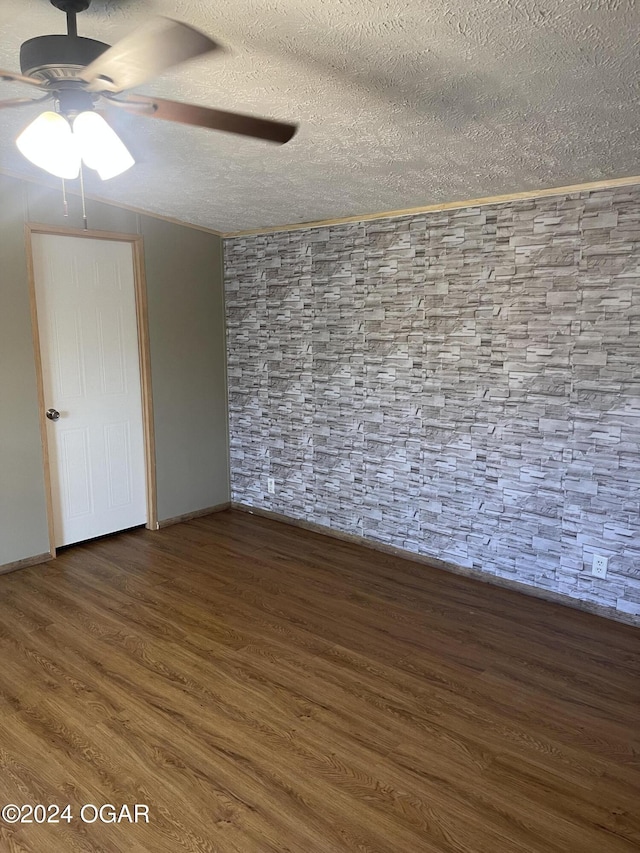 unfurnished room with ceiling fan, dark wood-type flooring, and a textured ceiling