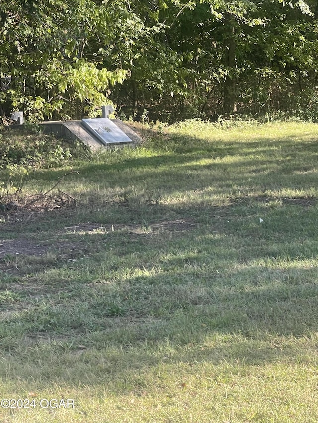 view of storm shelter featuring a lawn