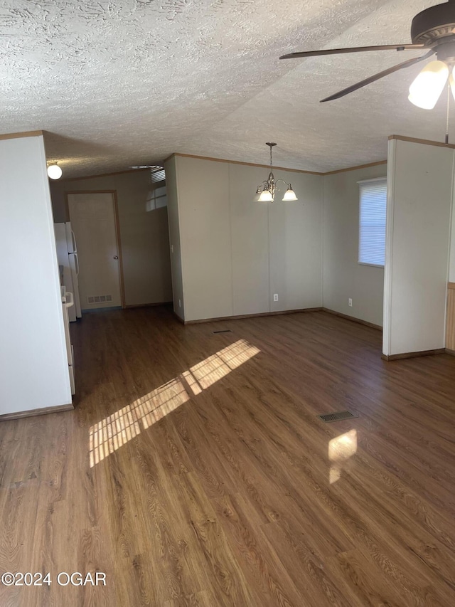 unfurnished living room featuring ceiling fan with notable chandelier, a textured ceiling, and dark wood-type flooring