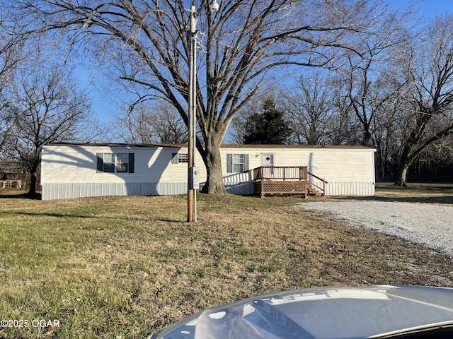 manufactured / mobile home with a front lawn and a wooden deck