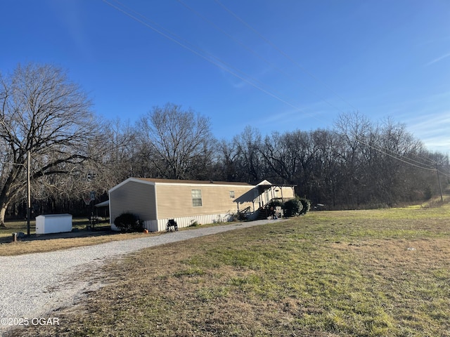 view of side of home with a yard, a carport, and an outdoor structure