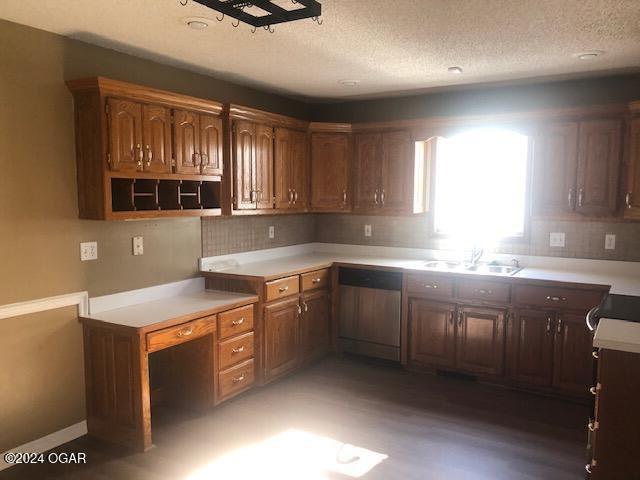 kitchen featuring a textured ceiling, a sink, light countertops, dishwasher, and open shelves