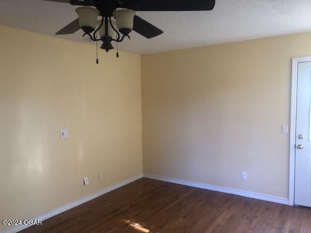 empty room with ceiling fan, baseboards, and wood finished floors