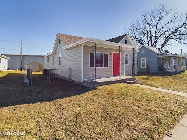 view of front facade featuring covered porch, a garage, an outdoor structure, and a front yard