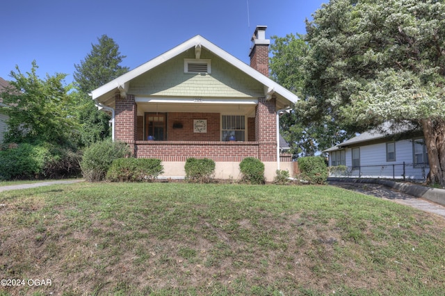 bungalow-style house with covered porch and a front lawn