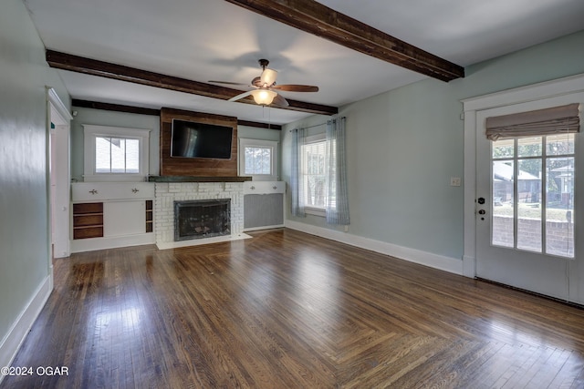 unfurnished living room with beamed ceiling, dark hardwood / wood-style floors, a wealth of natural light, and ceiling fan