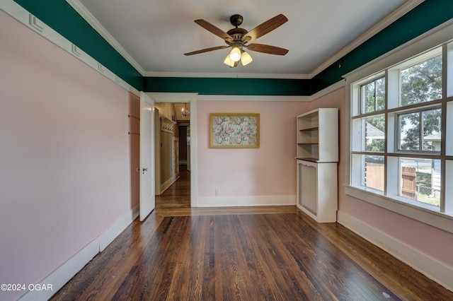 empty room with ceiling fan, dark wood-type flooring, and ornamental molding