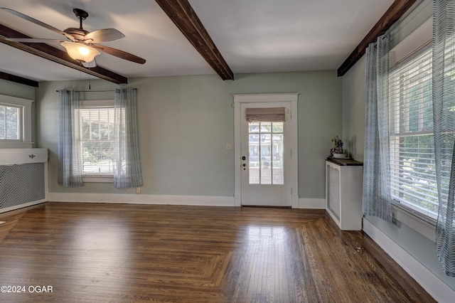 interior space with beamed ceiling, dark hardwood / wood-style floors, and a wealth of natural light