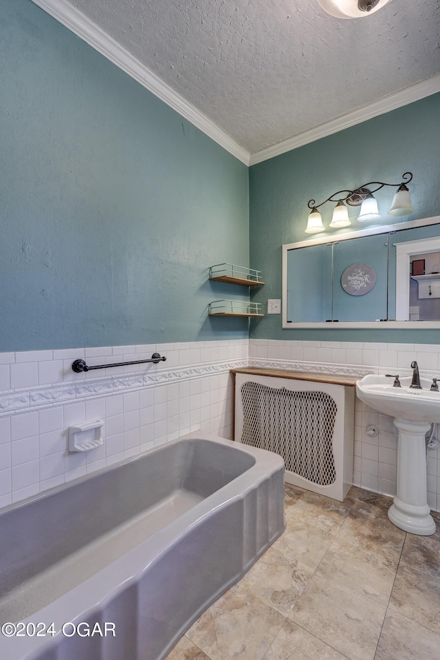 bathroom featuring a textured ceiling, crown molding, a bath, and tile walls