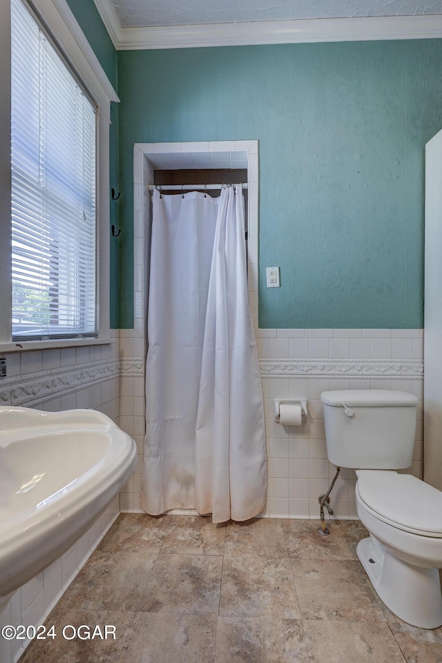 bathroom with crown molding, tile walls, and toilet