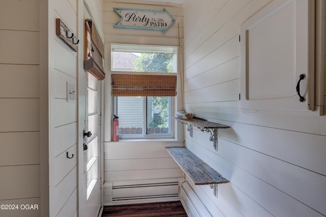 kitchen featuring wood walls, white cabinets, dark hardwood / wood-style floors, and a baseboard heating unit