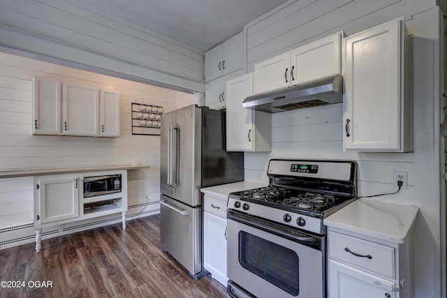 kitchen featuring white cabinetry, wood walls, dark hardwood / wood-style floors, and appliances with stainless steel finishes