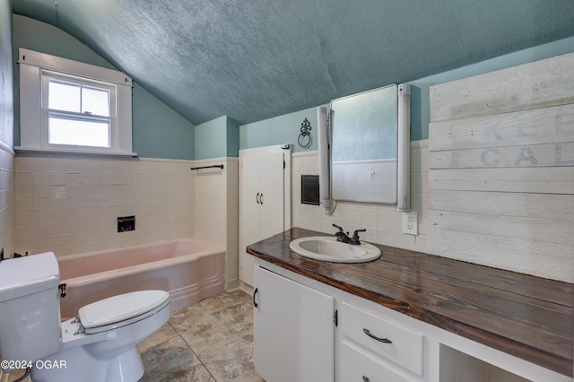 bathroom featuring a bathtub, vanity, a textured ceiling, toilet, and lofted ceiling