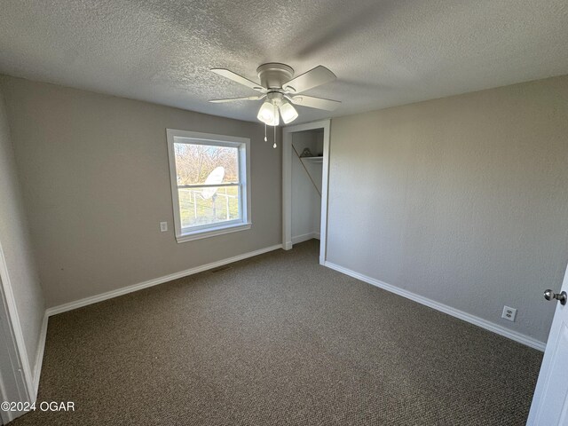 carpeted spare room with ceiling fan and a textured ceiling