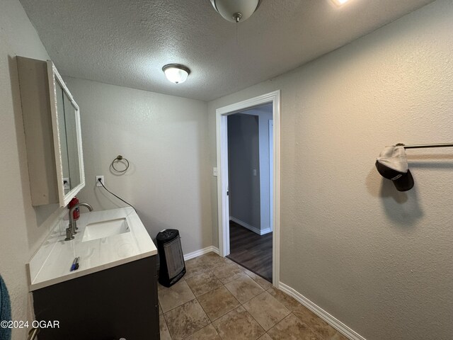 bathroom featuring tile patterned floors, vanity, and a textured ceiling