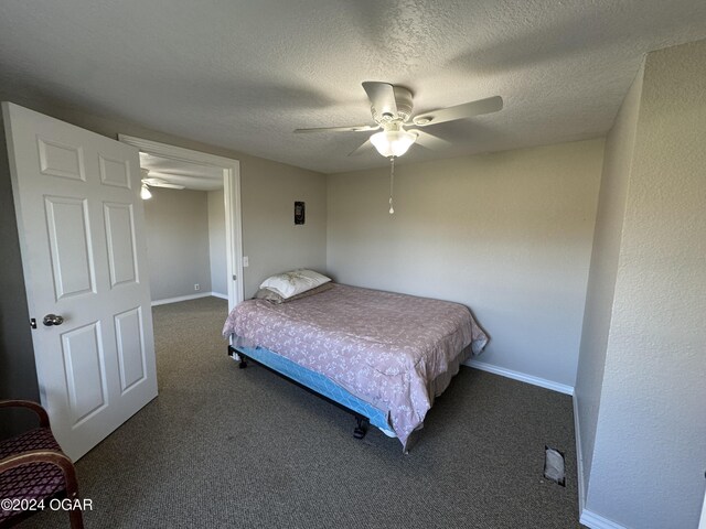 carpeted bedroom featuring ceiling fan and a textured ceiling