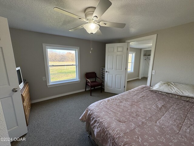 bedroom with dark carpet, multiple windows, and ceiling fan