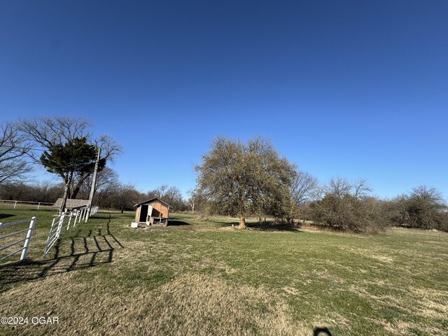 view of yard featuring a rural view and an outdoor structure