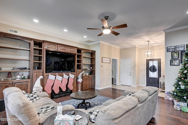 living room featuring ceiling fan with notable chandelier, wood-type flooring, and crown molding