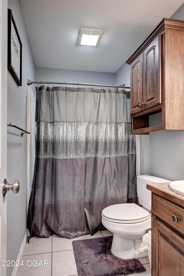 bathroom featuring tile patterned flooring, vanity, a textured ceiling, and toilet