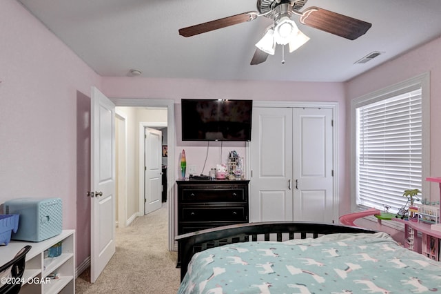 bedroom featuring light carpet, a closet, and ceiling fan