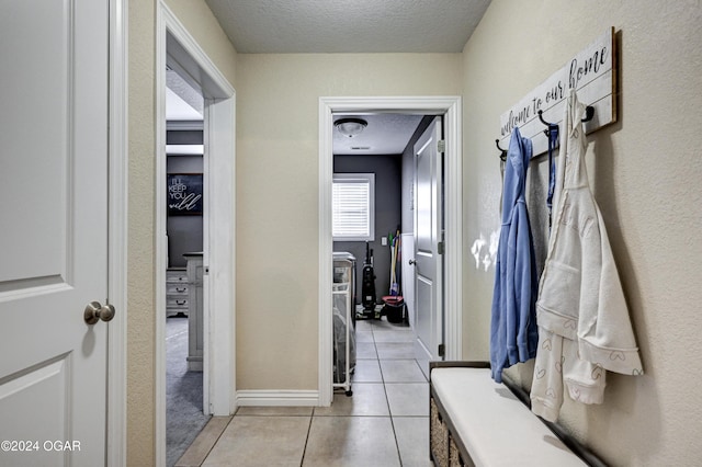 mudroom featuring light tile patterned floors and a textured ceiling