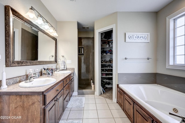 bathroom with shower with separate bathtub, vanity, and tile patterned floors