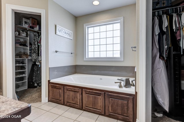 bathroom with tile patterned floors and a bath