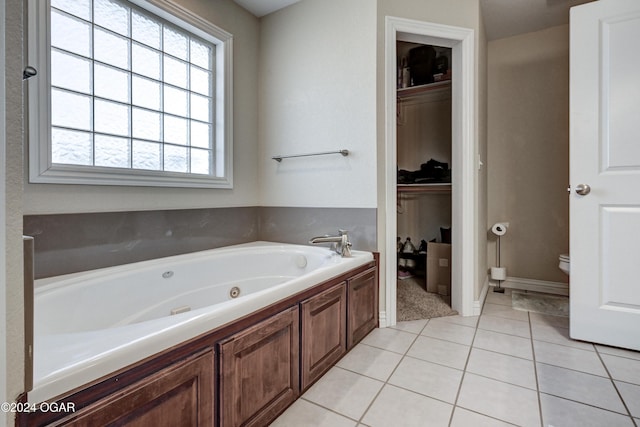 bathroom featuring tile patterned flooring, toilet, and a bath