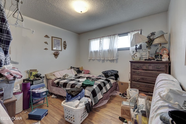 bedroom with wood-type flooring and a textured ceiling