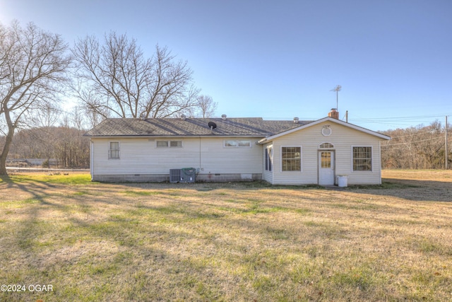 back of property featuring a lawn and central AC