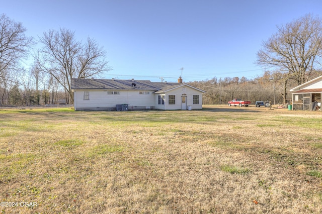 rear view of property featuring a lawn