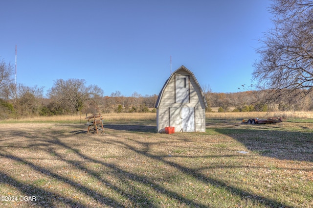 view of outdoor structure featuring a lawn and a rural view