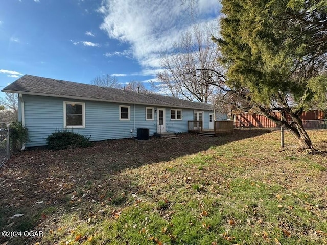 back of house with a yard, central air condition unit, and a wooden deck