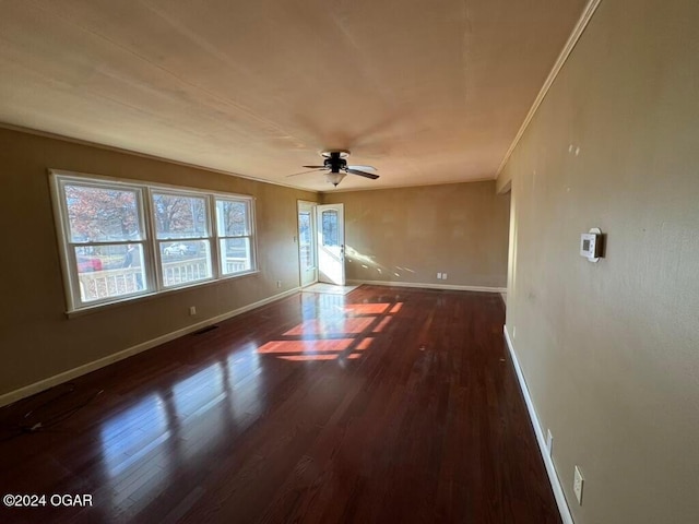 unfurnished room featuring ceiling fan, dark hardwood / wood-style flooring, and crown molding