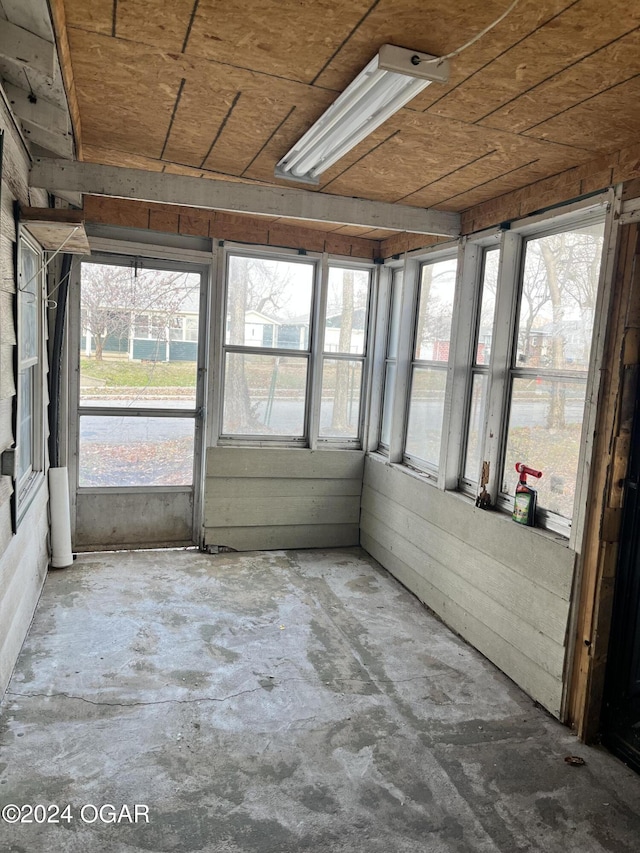 unfurnished sunroom featuring a healthy amount of sunlight and wood ceiling