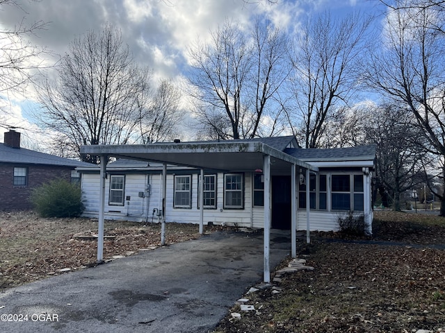 view of front of home featuring a sunroom and a carport