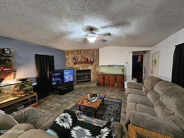 living room with a textured ceiling, a fireplace, and ceiling fan