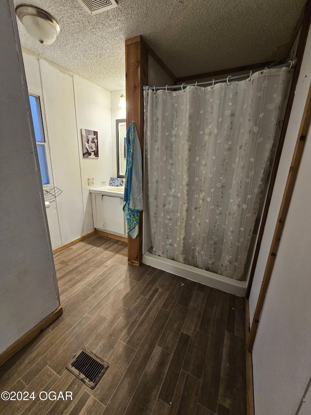 bathroom with a shower with curtain, vanity, and a textured ceiling