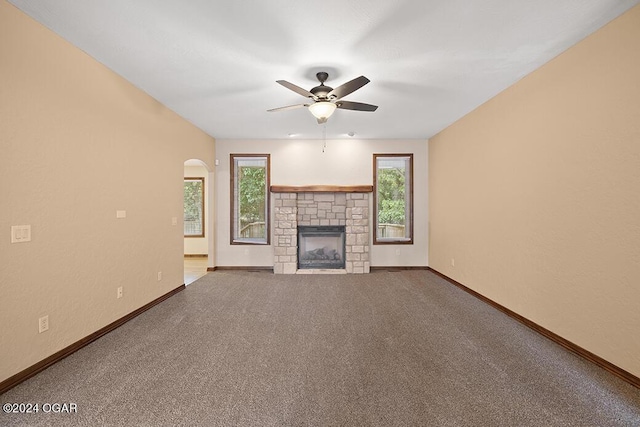 unfurnished living room featuring ceiling fan, a fireplace, and carpet floors