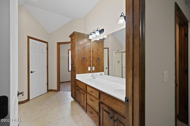 bathroom with tile patterned floors, a shower with door, vanity, and vaulted ceiling