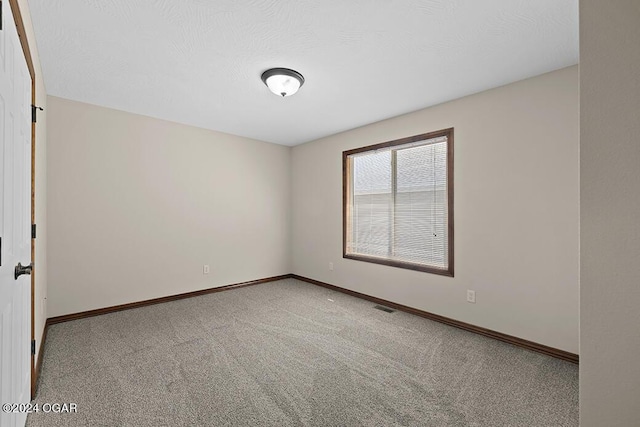 carpeted spare room with a textured ceiling