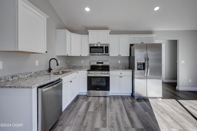 kitchen featuring white cabinetry, sink, appliances with stainless steel finishes, and light hardwood / wood-style flooring