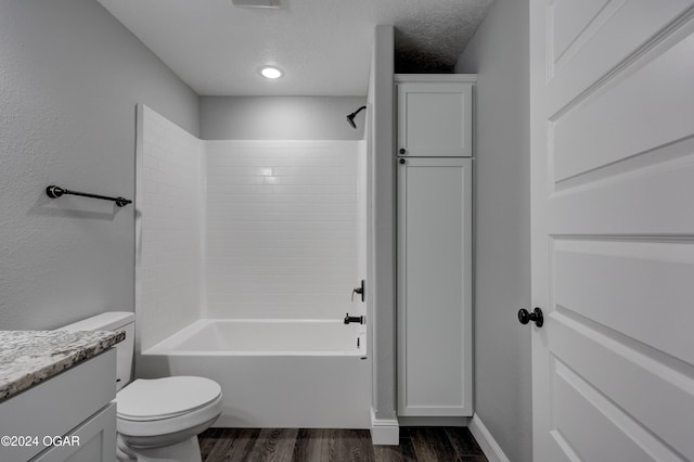 full bathroom featuring hardwood / wood-style floors, a textured ceiling, toilet, vanity, and bathtub / shower combination