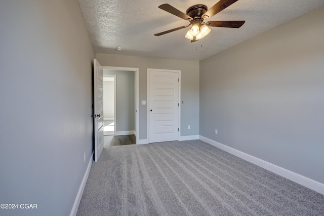 unfurnished bedroom featuring carpet, ceiling fan, a textured ceiling, and a closet